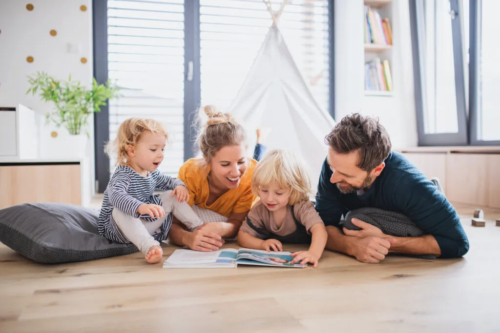 Família de quatro pessoas lendo uma revista Família de quatro pessoas lendo uma revista